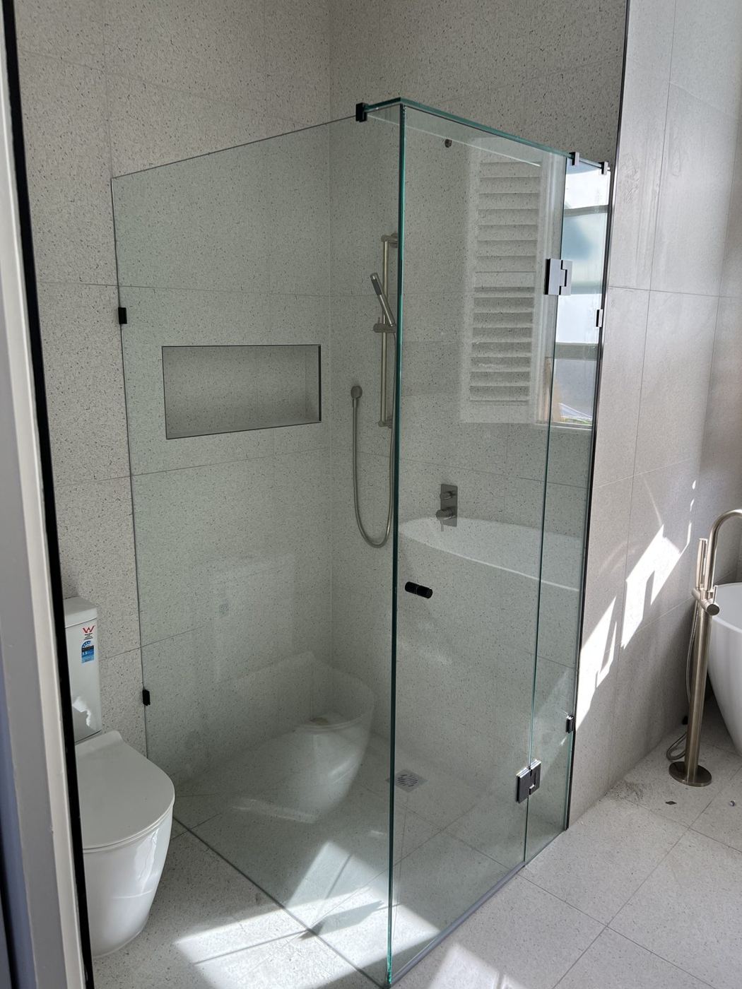 Frameless shower, black fittings