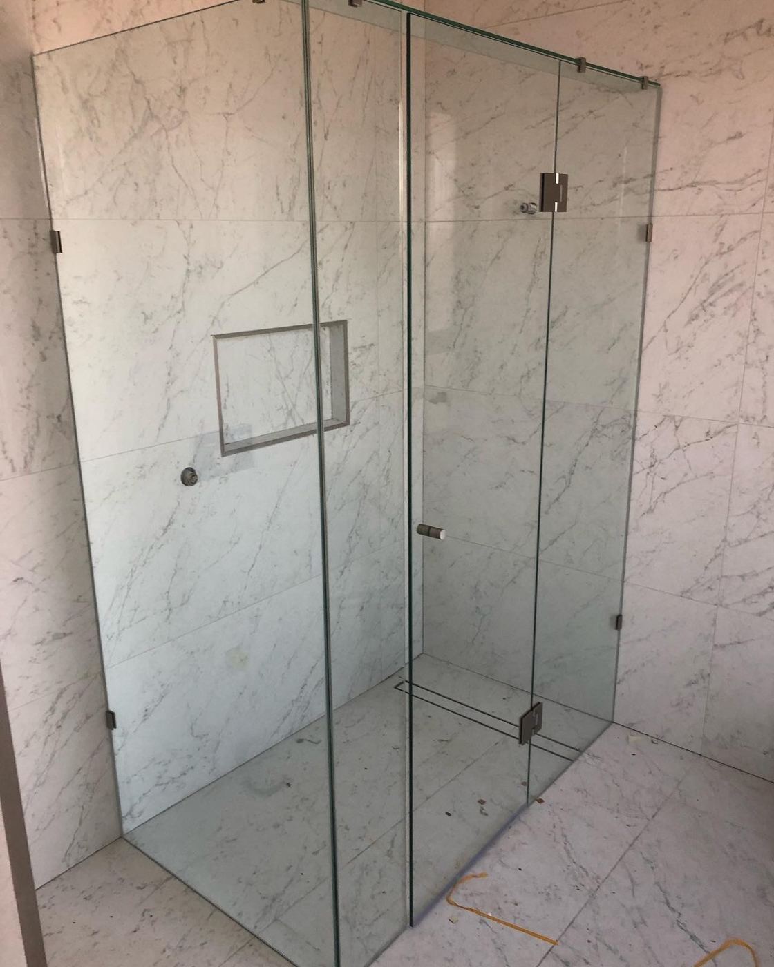 Frameless shower screen on marble tiles